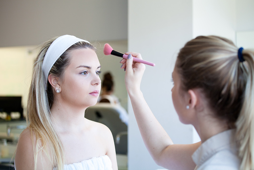Une apprenties pratique un soin de maquillage