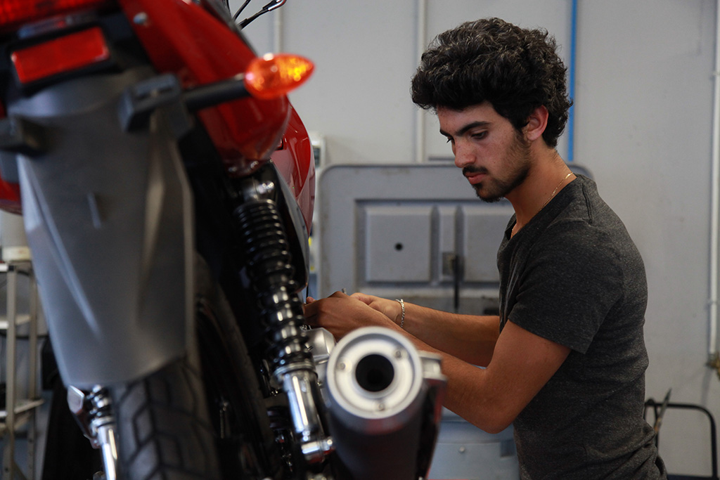 Un apprenti répare une moto