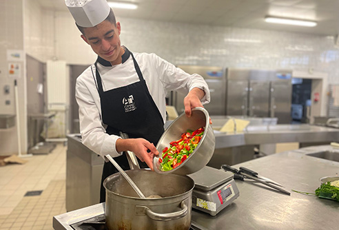 Préparation de légumes par un jeune homme